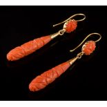 A pair of carved coral drop earrings: each with a single oval coral panel suspending a single coral