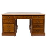 An Edwardian oak pedestal desk:, the rectangular top with a moulded edge,