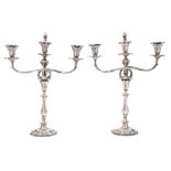 A pair of Victorian silver plated twin-branch candelabra: the urn shaped nozzles with foliate