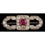A white metal, ruby and diamond oblong brooch: with central single,