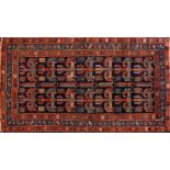 A Kurdish fertility rug:, the indigo field with two rows of hooked geometric medallions,