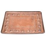 A Newlyn copper tray: of rectangular outline, with embossed fruit and foliate decoration,