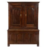 An 18th Century oak side cupboard:, in two parts, with a moulded cornice,