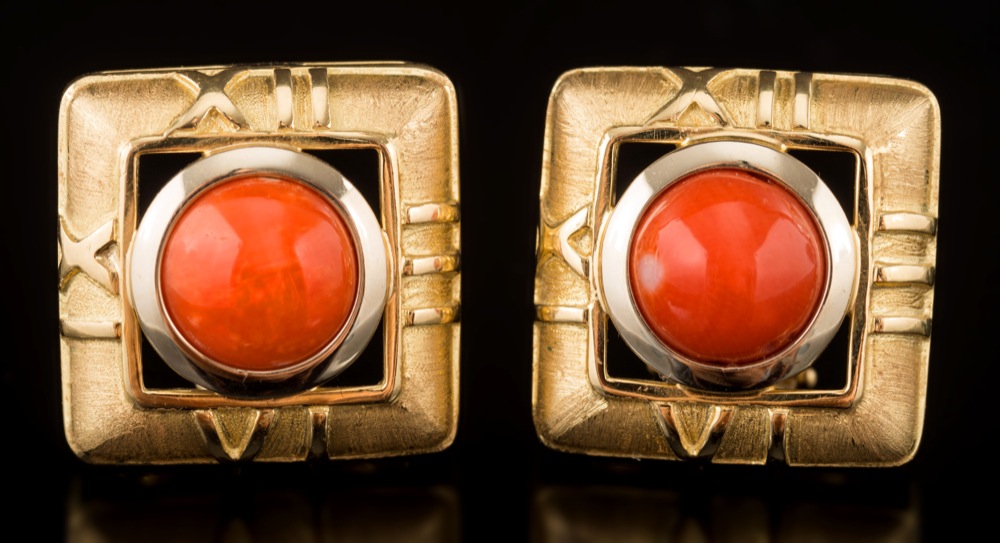 A pair of square coral single-stone stud/clip earrings: each centring a circular coral