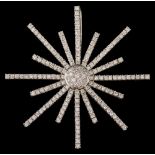 A modern diamond star burst pendant/brooch: pave-set with round brilliant-cut diamonds,