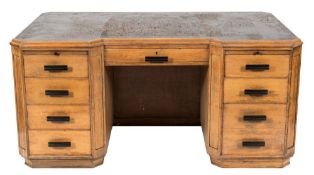 An Art Deco oak kneehole desk:, of breakfront and canted design,