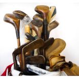 A golf club bag containing hickory shafted golf clubs: including mashie niblicks, jigger,