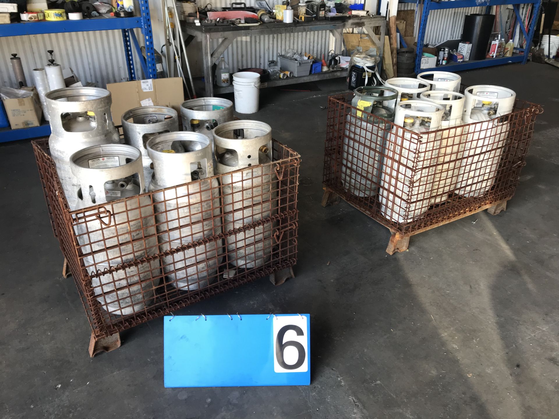 Lot 6 Aluminum Propane Tanks w/ Wire Baskets & 6 Steel Propane Tanks w/ Wire Baskets