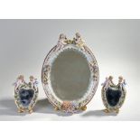 Continental porcelain easel mirror set, the larger with an oval mirror plate and foliate decorated