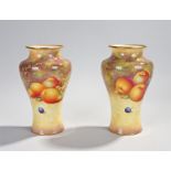 Pair of Royal Worcester vases, decorated by Alan Telford, each with a gold edge above a baluster