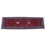 Persian runner, with a red field with stylised flowers, 340cm x 95cm