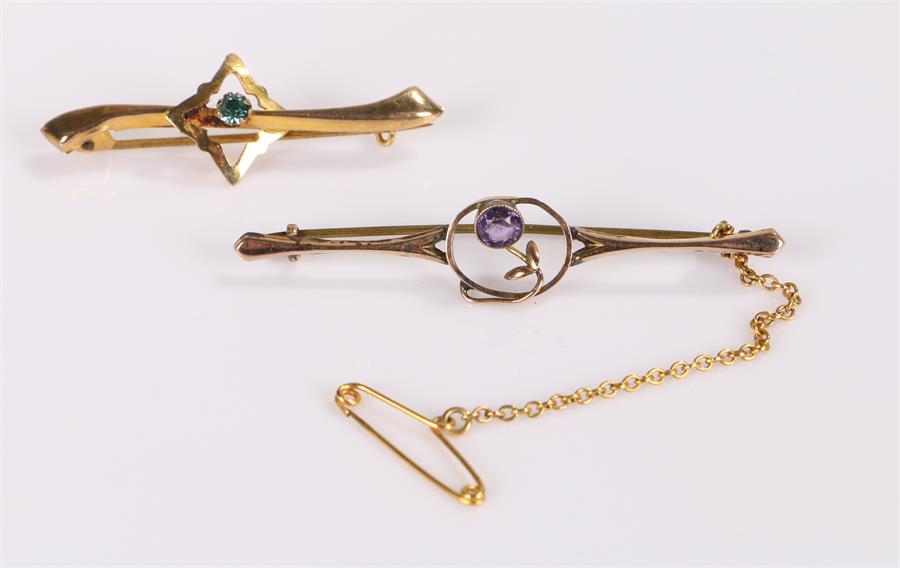 Two 9 carat gold brooches, one with a pale blue stone and the other with a purple stone, (2)