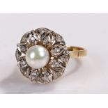 18 carat gold pearl and diamond ring, the central pearl with a flower head design set with round cut