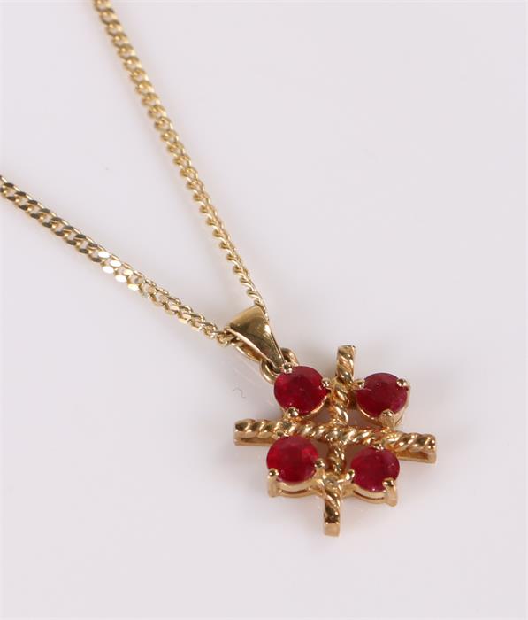 9 carat gold pendant necklace, set with four red stone, the pendant 12mm diameter