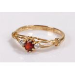 9 carat gold garnet set ring, with a central garnet flanked by cubic zirconia, ring size P