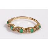 9 carat gold emerald set ring, with an undulating design