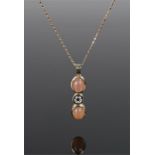 18 carat gold diamond set pendant necklace, the centre of the pendant with diamonds flanked by peach