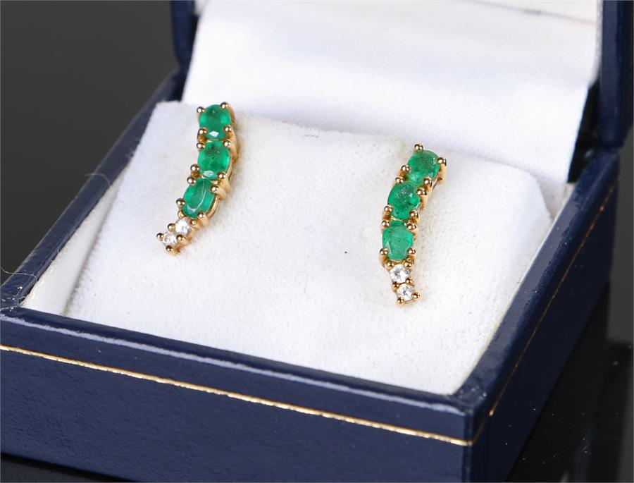 Pair of 18 carat gold emerald and diamond set earrings, each with three emeralds above two diamonds,