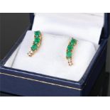 Pair of 18 carat gold emerald and diamond set earrings, each with three emeralds above two diamonds,