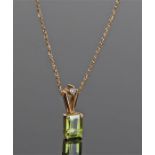 18 carat gold peridot pendant necklace, the emerald cut peridot with a diamond above, the pendant