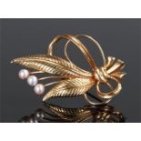 18 carat gold pearl set brooch, in the form of bow tied leaves with pearl berry heads, 47mm long