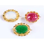 Three yellow metal brooches, set with a moonstone, jade and cabochon red stone, (3)