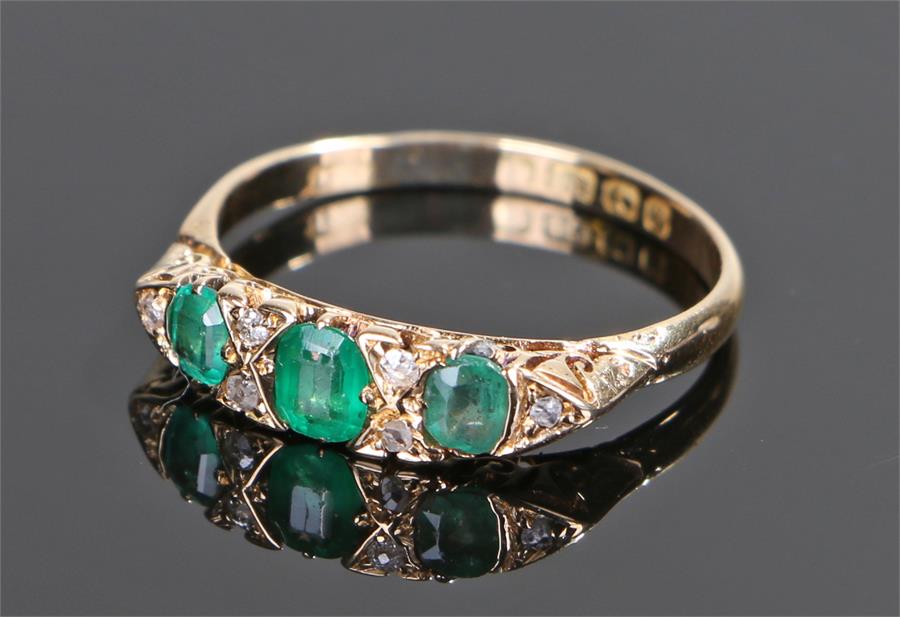 18 carat gold emerald and diamond set ring, the head with three emeralds and six diamonds, ring size