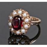 9 carat gold garnet and pearl set ring, the central garnet with a pearl surround, ring size L