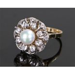 18 carat gold pearl and diamond ring, the central pearl with a flower head design set with round cut