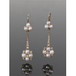 Pair of pearl and diamond set earrings, the pearl top above a diamond stem and pearl foliate head,