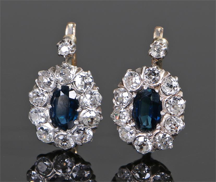 Pair of sapphire and diamond set earrings, the central sapphire with diamond surround, 17mm high