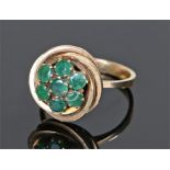 14 carat gold emerald set ring, the head set with seven emeralds to form a flower head, ring size M