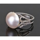 Pearl set ring, with a half pearl above the white metal shank, ring size M