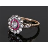18 carat gold diamond and ruby ring, the central round cut diamond with a ruby and further