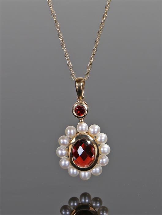 9 carat gold pearl set pendant necklace, the pendant with a central red stone and pearl surround,