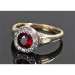 Garnet and diamond set ring, the central garnet with diamond surround, ring size P 1/2