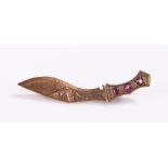 Kukri brooch, in yellow metal set with three red stones, 2.7 grams