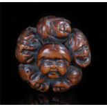 Meiji period carved wooden netsuke formed as a group of masks 40mm diameter