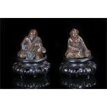 Two Meiji period Japanese seated figures, of a bearded man with topknot in ornate robe and a women