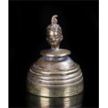 Early 20th century brass bell, surmounted by a turban head, height 5.5cm