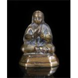 Late 19th century brass figure of a priest, seated and hand clasped in anjali-madra, height 5cm