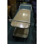 Veneered gilt metal two tier tea trolley on castors