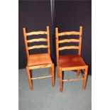 Two pine ladder back dining chairs with upholstered seats