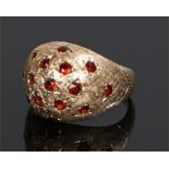 14 carat gold garnet set ring, the raised dome head set with sixteen garnets, ring size J, 4.7