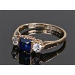 9 carat gold sapphire set ring, the central emerald cut sapphire flanked by cubic zirconia, ring