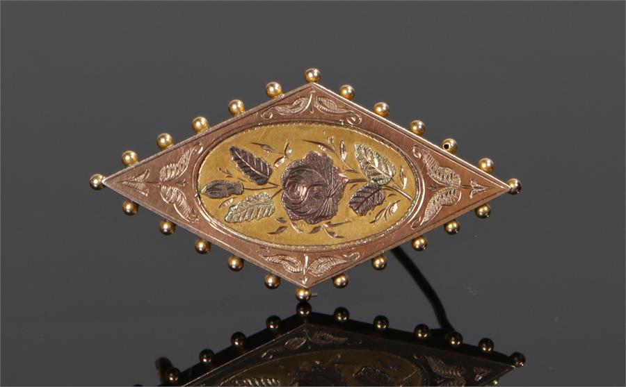 9 carat gold brooch, with a central flower design to the diamond shape brooch, 42mm diameter