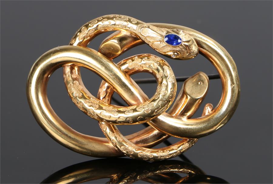 Sapphire snake brooch, the head of the snake set with a sapphire above the winding coiled body, 60mm