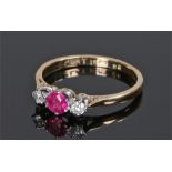 18 carat gold ruby and diamond ring, the central ruby flanked by a diamond to either shoulder,