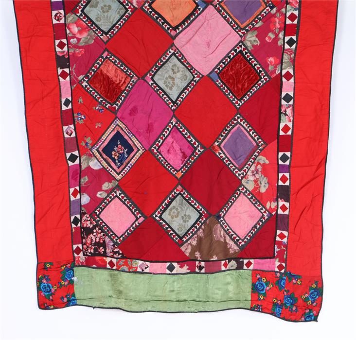 Turkish patchwork wall hanging, with diamond pattern centre surrounded by a red, green and floral