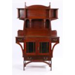 Liberty style Arts and Crafts mahogany desk, with turned finials above an open bookshelf with angled